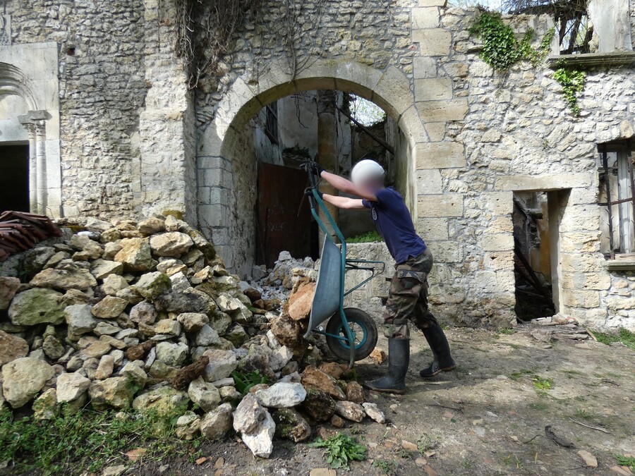 Décharge de pierres avec une brouette par un jeune